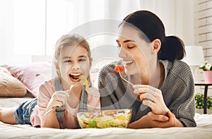 Mother and daughter eating salad