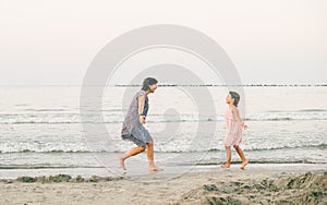 Mother and daughter enjoy together at sunet on the beach