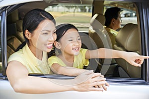 Mother and daughter enjoying view from car window