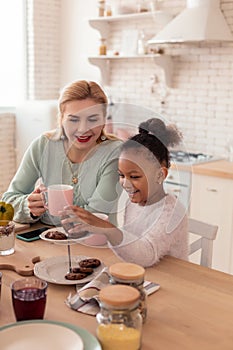 Mother and daughter feeling happy enjoying breakfast together