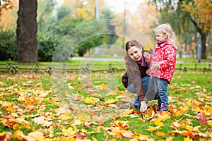 Mother and daughter gathering maple leaves