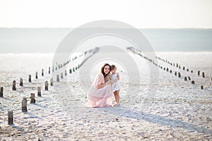 Mother daughter girl woman child sit sand white water love family