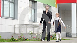 Mother and daughter go home from modern primary school