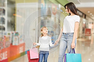 Mother and daughter going in mall and shopping together