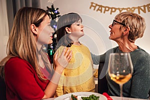 Mother, daughter and granddaughter bonding on family Christmas dinner