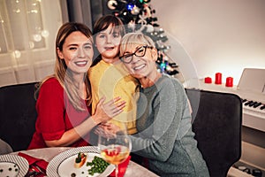 Mother, daughter and granddaughter bonding on family Christmas dinner
