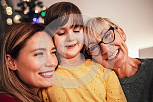 Mother, daughter and granddaughter bonding on family Christmas dinner