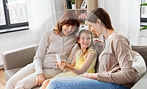 Mother, daughter and grandmother with smartphone