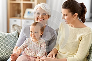 Mother, daughter and grandmother on sofa at home