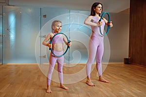 Mother and daughter in gym, pilates with rings