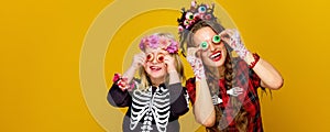 Mother and daughter in halloween costume having fun time