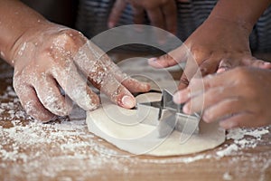 Mother and daughter hands prepare a dough for baking cookies