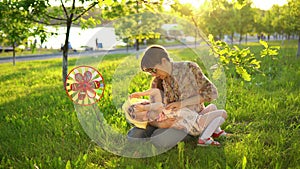 Mother and daughter happily spend time playing together on the grass at sunset.