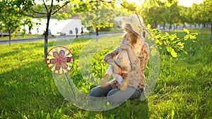 Mother and daughter happily spend time playing together on the grass at sunset.