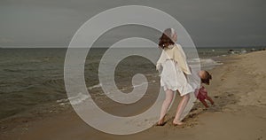 Mother and daughter have fun playing and fooling around on the beach together