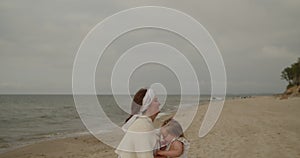 Mother and daughter have fun playing and fooling around on the beach together