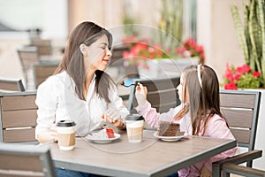 Mother and daughter having cake at restaurant