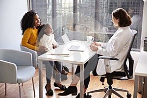 Mother And Daughter Having Consultation With Female Pediatrician In Hospital Office