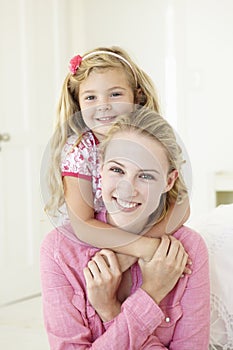 Mother And Daughter Having Cuddle Together At Home