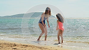 Mother and daughter having fun at the beach 4k