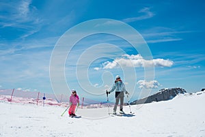 Mother and daughter having fun and learning skiing making first steps on a ski winter resort at mountain hill.