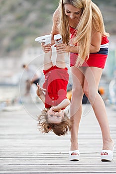 Mother and daughter having fun outside on the dock