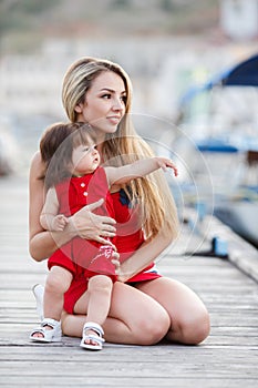 Mother and daughter having fun outside on the dock