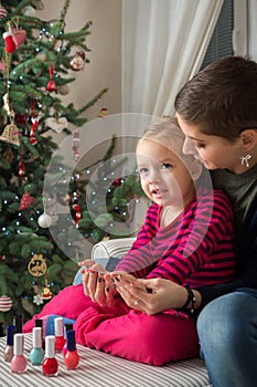 Mother and daughter having fun painting finger nails photo