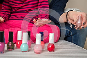 Mother and daughter having fun painting fingernails