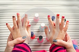 Mother and daughter having fun painting fingernails