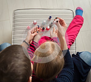 Mother and daughter having fun painting fingernails