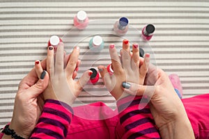 Mother and daughter having fun painting fingernails, view from above