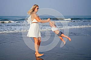 Mother daughter having fun resting on the beach. Family vacation travel . Caucasian female with toddler baby at ocean .