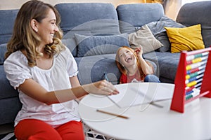 Mother and daughter having fun studying and doing homework