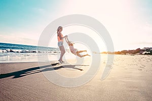 Mother and daughter having fun on tropical beach - Mum playing with her kid in holiday vacation next to the ocean - Family