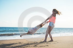 Mother and daughter having fun on tropical beach - Mum playing with her kid in holiday vacation next to the ocean - Family