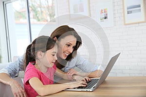 Mother and daughter having fun websurfing on a laptop