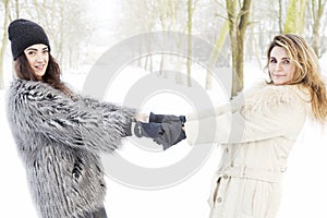 Mother and daughter holding hands in the snow