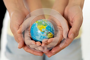 Mother and daughter holding world globe in eduction and protection concept