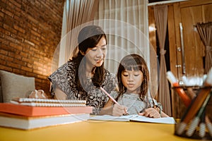 Mother and daughter home schooling studying together photo