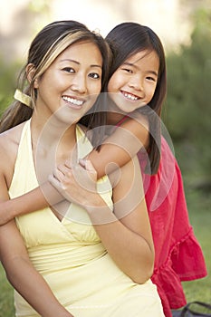 Mother And Daughter Hugging In Garden