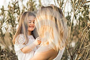 Mother and daughter hugging in nature at summer