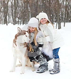 Mother with daughter with huskies dog