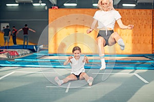 Mother and daughter jumping on trampoline and doing split