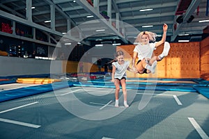 Mother and daughter jumping on trampoline and doing split