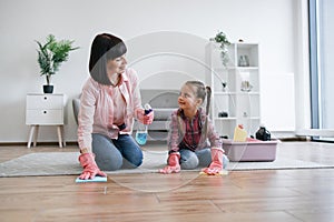 Mother and daughter keeping eye contact while washing floor