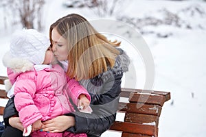 Mother and daughter kiss. Winter fun.