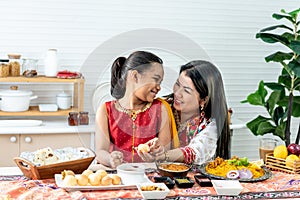 mother and daughter in the kitchen They happy together while eating Indian food