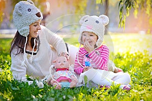 Mother and daughter in knit hats bears in the park