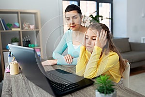 Mother and daughter with laptop doing homework